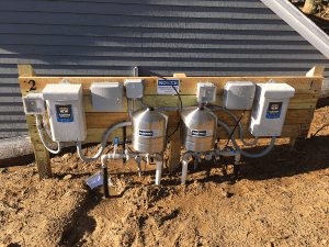 Outdoor installation tank, tank manifold and constant pressure controller on a pressure treated pedestal for an irrigation well.